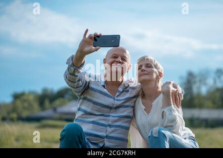 joyeux couple senior datant, prenant le selfie et s'amuser en plein air Banque D'Images
