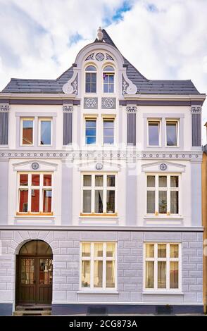 Ancienne façade grise avec fenêtres en bois blanc dans la vieille ville de Wismar. Banque D'Images