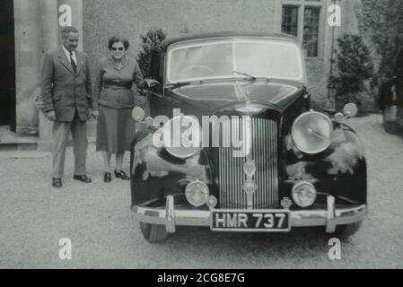 Collectez la photo vers 1955 de Joseph et Sybil Atwell à côté de leur 1951 Austin Sheerline A125. Le fils de Joseph Richard Atwell, 65 ans, de Calne, Wiltshire, a racheté l'Austin Sheerline A125 après que son père l'ait vendu il y a près de quarante ans. Richard Atwell, passionné de moto et conservateur de musée, a traqué la rare voiture britannique et a été surpris de constater qu'elle était encore sur la route après que son père l'a vendue en 1965. Banque D'Images