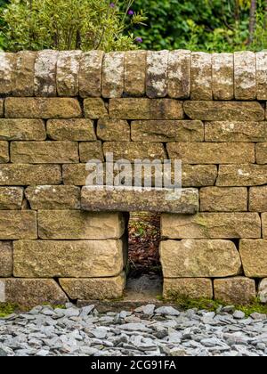 Petit couloir pour animaux ou autoroute pour hérisson dans un nouveau mur de jardin. ROYAUME-UNI. Banque D'Images