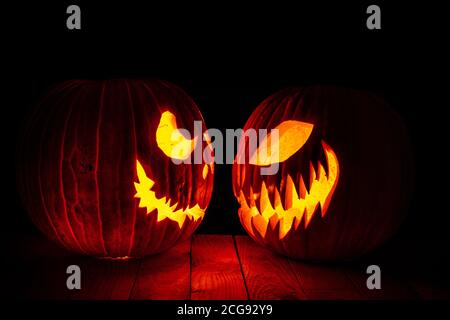 citrouilles d'halloween sculptées, vue latérale. base en bois et fond noir. Banque D'Images