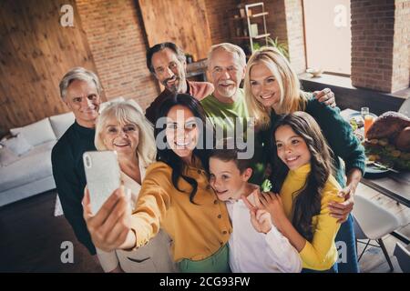 Portrait de belle belle belle grande famille gaie frère sœur profitez d'une occasion festale en prenant des sekfie montrant le v-sign dans un loft moderne industriel Banque D'Images