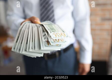 L'homme tient dans sa main un ventilateur de cent dollars billet de banque Banque D'Images