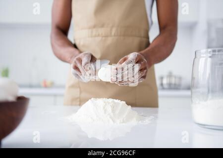 Courte vue en gros plan de son elle belle attrayante guy confiserie faire du pain frais doux en oughing farine casser des œufs cuisine dans un cadre moderne Banque D'Images