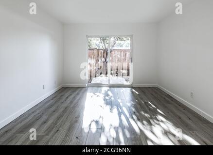 Chambre vide avec de grandes portes vitrées menant à une cour Banque D'Images