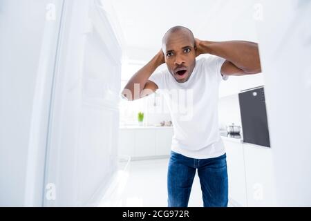 Portrait de son beau beau attrayant inquiet effrayés gars étourdi regarder dans le réfrigérateur vide après la fête manque de produits sains blanc clair moderne Banque D'Images