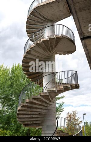 Escalier en colimaçon en béton avec mains courantes en métal pour la circulation piétonne jusqu'au pont. Banque D'Images