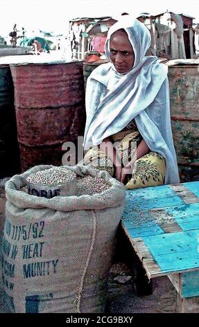 Une femme somalienne est assis face à la caméra et derrière une table en attente de passer des grains pour les résidents de son centre d'alimentation de Mogadishu, Somalie. C'est l'un des 35 sites qui avaient les livraisons de vivres escorté par les forces de la coalition. Cette mission est en appui direct à l'Opération Restore Hope. Banque D'Images