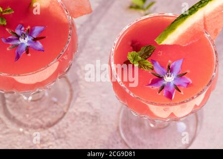 Deux verres de jus de pastèque décorérés d'une plante de bourrache fraîche Banque D'Images