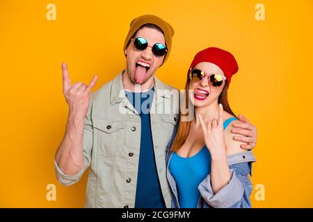 Photo de funky folle dame Guy jeune couple rock concert temps libre ensemble jeune cool montrant des cornes bâton de langue usure vêtements d'été décontractés isolés Banque D'Images