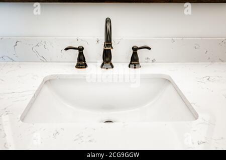 Lavabo dans une salle de bains avec robinet à l'ancienne et un comptoir en marbre Banque D'Images