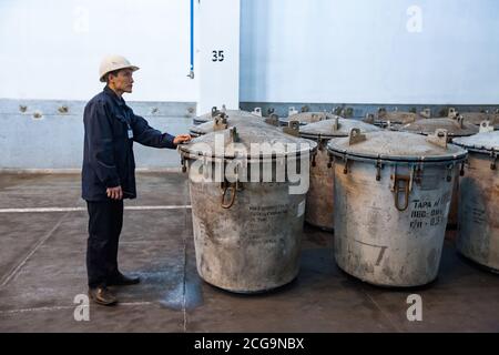 Usine de métallurgie du titane. Ingénieur métallurgiste dans un entrepôt de titane. Réservoirs de stockage spéciaux (seaux) pour éponge en titane pour le traitement de la matière fondue. Banque D'Images