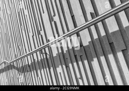 Main courante projetant une ombre contre des motifs verticaux sur un mur à Liverpool. Banque D'Images