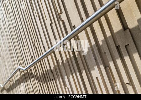 Rail en zigzag vu à Liverpool devant des motifs verticaux sur un mur. Banque D'Images