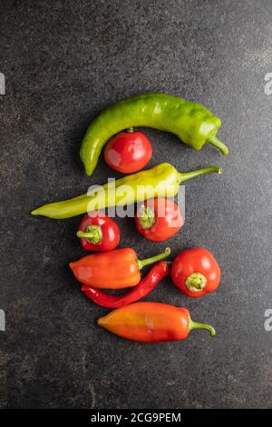 Différents types de légumes poivrons sur table noire. Vue de dessus. Banque D'Images