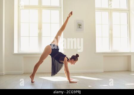 Bonne belle apparence mince femme gymnaste se préparer à faire un stand dans un studio moderne Banque D'Images