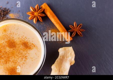 Thé Chai de masala sur fond noir. Boisson traditionnelle indienne - thé masala avec épices sur un tableau d'ardoise. Copier l'espace. Vue de dessus Banque D'Images