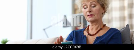 Une dame concentrée qui tape sur son smartphone Banque D'Images