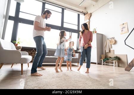 bonne famille mère père et enfant fille dansant à la maison. Banque D'Images