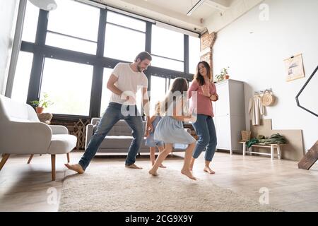 bonne famille mère père et enfant fille dansant à la maison. Banque D'Images