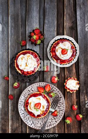 Tartelettes à la fraise meringue sur fond rustique en bois Banque D'Images