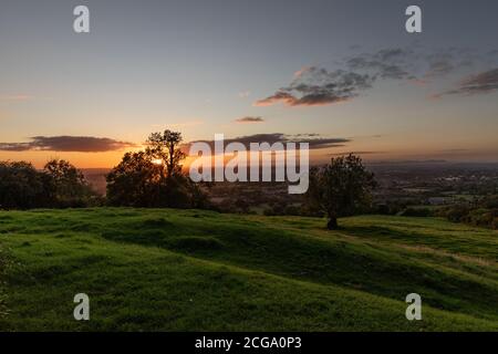 Le soleil cadre. Vue de Lashampton Hill sur la route en allant dans la ville de Spa local dans les Cotswolds appelé Cheltenham dans Gloucestershire Angleterre. Banque D'Images