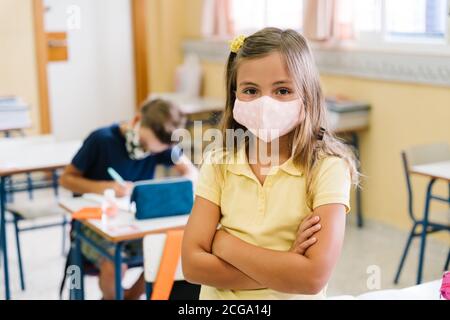Les enfants dans leur classe scolaire portant des masques pendant le covid pandémie Banque D'Images