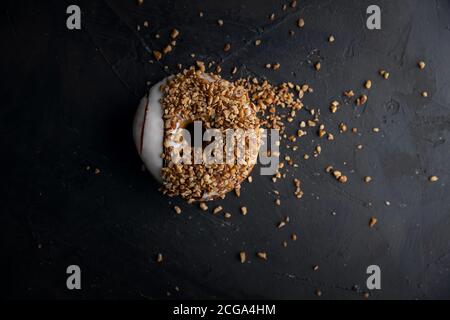 Beignet couvert de noix hachées, nourriture foncée Photographie Banque D'Images