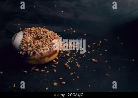 Beignet couvert de noix hachées, nourriture foncée Photographie Banque D'Images