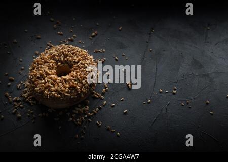 Beignet couvert de noix hachées, nourriture foncée Photographie Banque D'Images