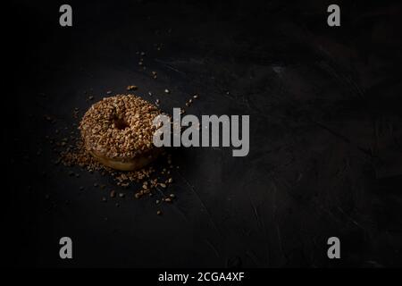 Beignet couvert de noix hachées, nourriture foncée Photographie Banque D'Images