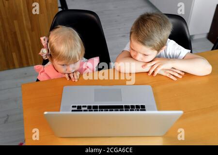 Un petit garçon et une fille regardent des dessins animés sur un ordinateur portable Banque D'Images