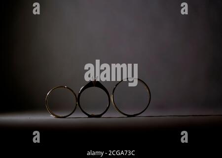 Belle photo aux tons avec des anneaux de mariage sur un bois surface sur le fond d'un bouquet de fleurs Banque D'Images