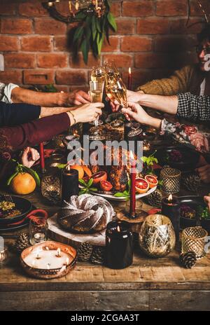 La famille ou les amis se trinquent avec des verres pendant le dîner de Noël Banque D'Images