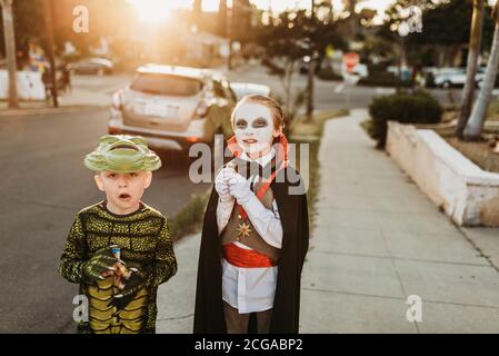 Les jeunes frères vêtus de costumes trick-or-Treating sur Halloween Banque D'Images