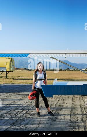 Jeune femme skydiver avec sac à dos dans un aérodrome Banque D'Images