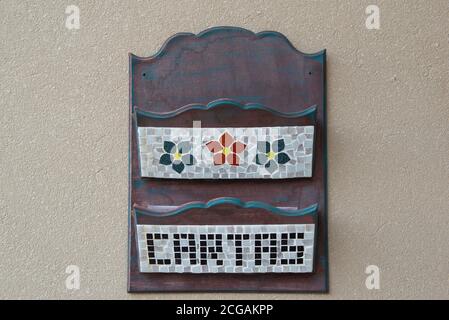 boîte aux lettres en bois avec compartiments pour la correspondance décorée de fleurs dessinées par des éclats de céramique (mosaïque) et des lettres écrites (cartas). Copier l'espace. Banque D'Images