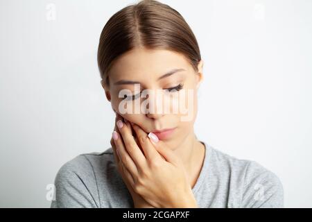 Gros plan d'une belle jeune femme éprouvant une douleur mal de dents Banque D'Images