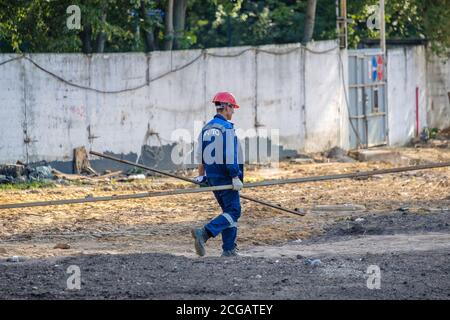 Moscou. Russie. 06 septembre 2020 les travailleurs de la construction qui travaillent dans les uniformes et les casques de sécurité sur le chantier transfèrent manuellement la construction Banque D'Images
