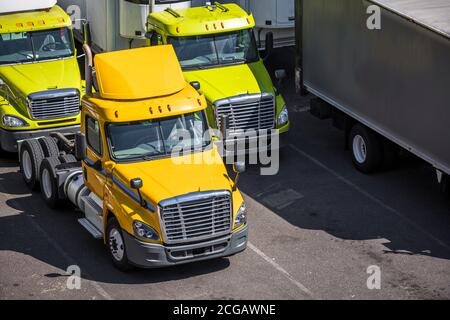 Poids moyen de transport professionnel engins puissants semi-camions industriels diesel avec semi-remorques réfrigérées sur la rue d'entrepôt serrée pa Banque D'Images