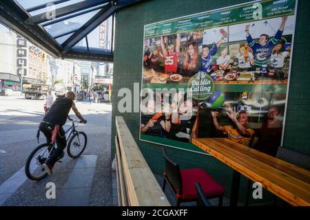 Vancouver, Canada. 9 septembre 2020. Un cycliste passe par une affiche sur le mur d'un bar de la rue Granville, à Vancouver (Colombie-Britannique), Canada, le 9 septembre 2020. Comme de plus en plus de preuves ont trouvé que les boîtes de nuit et les bars sont les sources qui ont mené à la reprise des cas COVID-19 à Vancouver, l'autorité sanitaire a ordonné de fermer immédiatement toutes les boîtes de nuit et les salles de banquet. Credit: Liang Sen/Xinhua/Alay Live News Banque D'Images