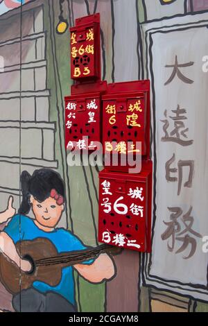 Œuvres d'art sur un bâtiment de réaménagement de palissade avec l'ancien style Hong Kong boîtes aux lettres en rouge Banque D'Images