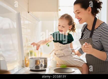 Une alimentation saine à la maison. Bonne famille dans la cuisine. La mère et l'enfant en fille préparent le bon repas. Banque D'Images