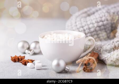 Tasse blanche avec café et guimauve, chandail, cannelle. Composition de noël confortable. Concept de l'hygge mise au point douce - image Banque D'Images