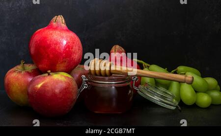 Miel, grenade et pommes sur la table noire. Carte postale du nouvel an juif Rosh Hashanah. Banque D'Images