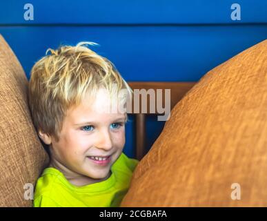 Portrait espiègle mignon blond bleu eyed garçon faisant des taches de rousseur visage jouer en riant dans l'humeur heureuse. Photo amusante, style de vie de bonheur. Garderie, joies simples Banque D'Images