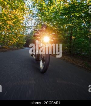 Conducteur de moto dans le paysage de Foreste. Photo de style de vie au coucher du soleil. Banque D'Images