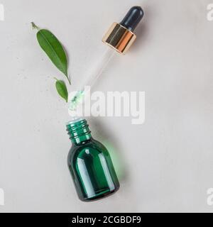 Bouteille avec pipette et ingrédients à base de plantes, concept de cosmétiques naturels Banque D'Images