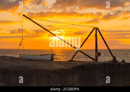 Portland Bill, Dorset, Royaume-Uni. 10 septembre 2020. Météo Royaume-Uni. Le ciel brille d'orange au lever du soleil derrière une grue sur la côte rocheuse de Portland Bill à Dorset. Crédit photo : Graham Hunt/Alamy Live News Banque D'Images