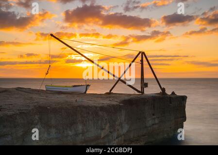 Portland Bill, Dorset, Royaume-Uni. 10 septembre 2020. Météo Royaume-Uni. Le ciel brille d'orange au lever du soleil derrière une grue sur la côte rocheuse de Portland Bill à Dorset. Crédit photo : Graham Hunt/Alamy Live News Banque D'Images